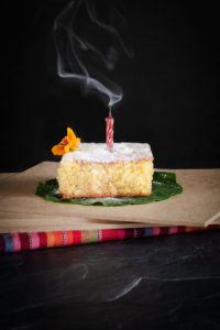 birthday cake with small flower on top blown out candle and smoke